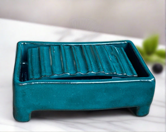 Handmade pottery two piece soap dish. The dish has a rippled insert that sits snuggly inside the dish. the soap sits on the rippled insert allowing any water to drain into the dish. keeping mess to a minimum. tactile and glazed in a jade green