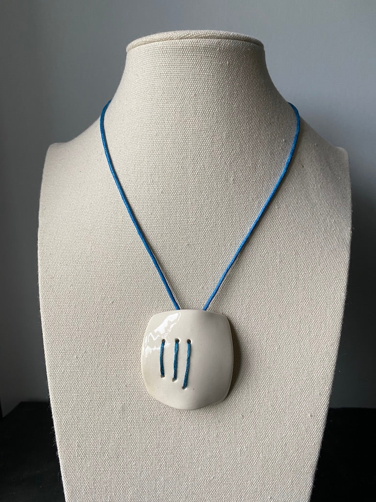 Square domed handmade ceramic pendant necklace. Glossy white with electric blue stitching totally unique