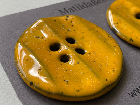 Pair of Extra Large Rippled Black Clay Buttons - 49mm - Yolky Yellow Glaze