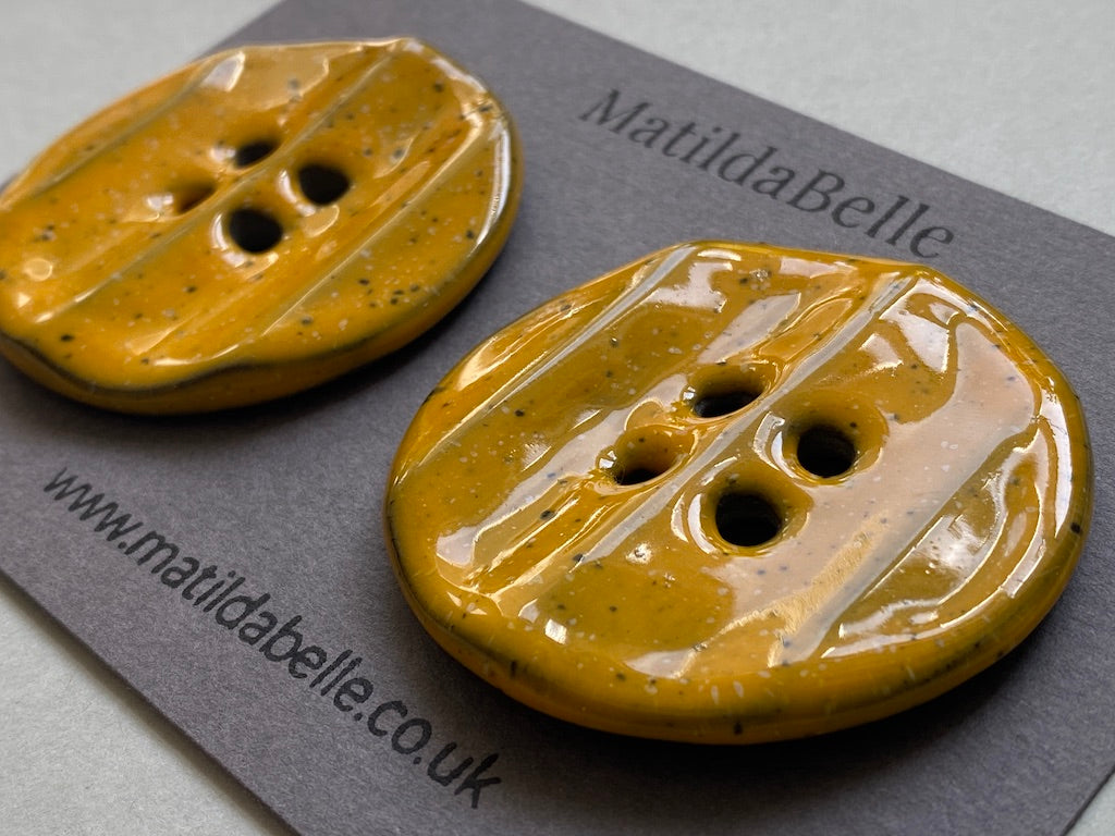 Pair of Extra Large Rippled Black Clay Buttons - 49mm - Yolky Yellow Glaze