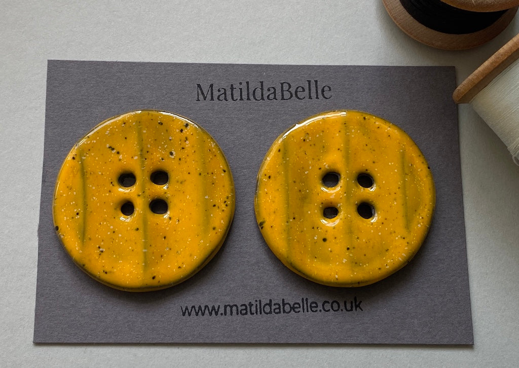 Pair of Extra Large Rippled Black Clay Buttons - 49mm - Yolky Yellow Glaze