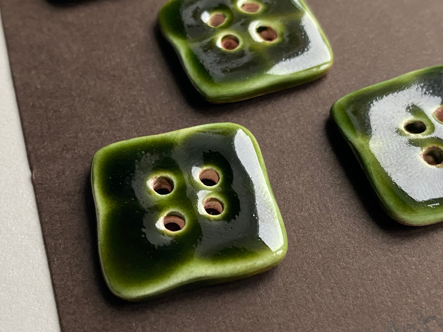 Green ceramic buttons on a brown surface