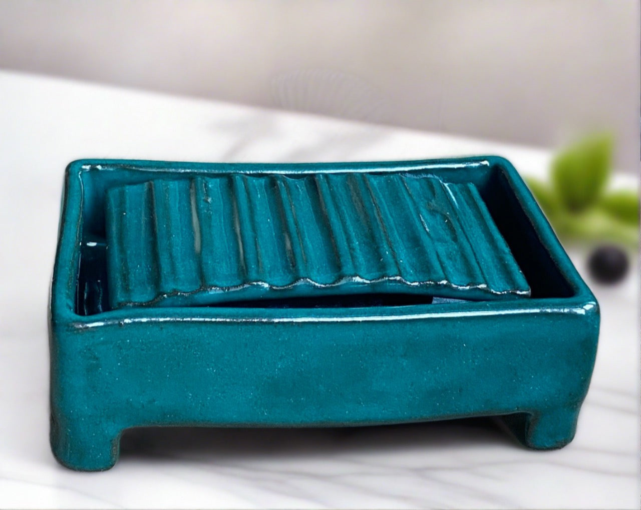 Handmade pottery two piece soap dish. The dish has a rippled insert that sits snuggly inside the dish. the soap sits on the rippled insert allowing any water to drain into the dish. keeping mess to a minimum. tactile and glazed in a jade green